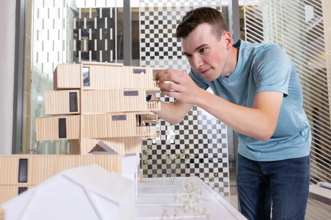 A person working on an 拱itectural model.